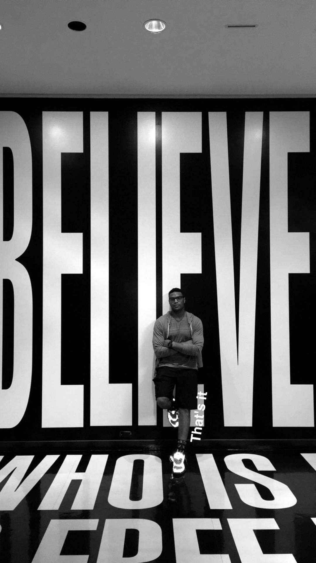 Eric standing in front of Believe mural